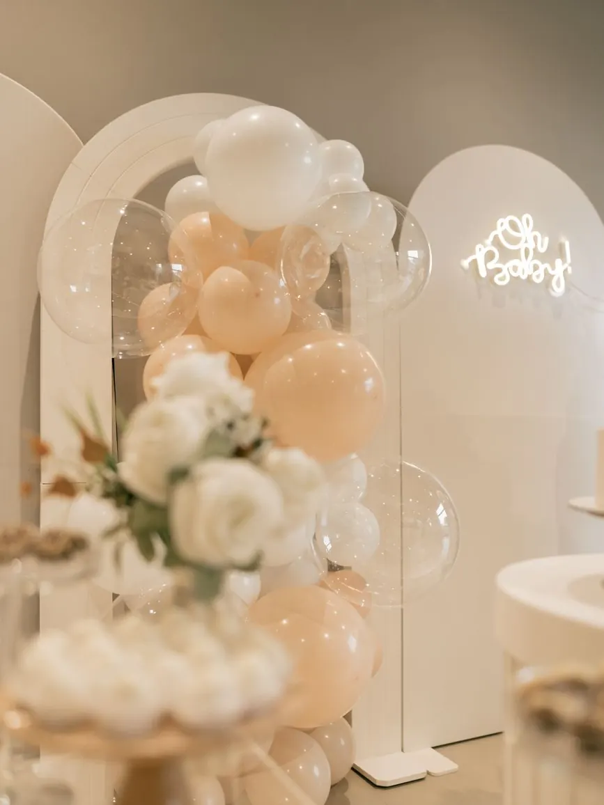 Arche de ballons et sweet table fleurie pour une baby shower dans un jardin de riad