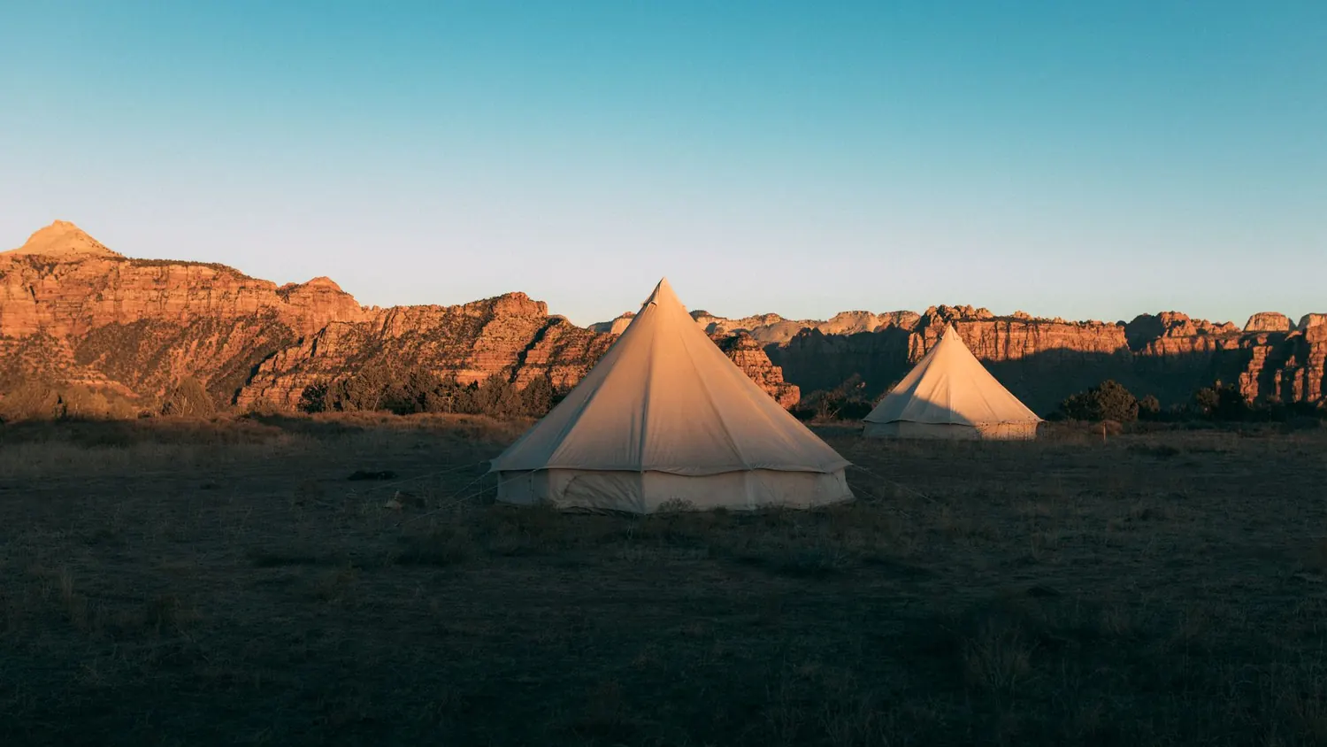 Camp privatisé du désert d'Agafay avec tente berbère illuminée au coucher du soleil