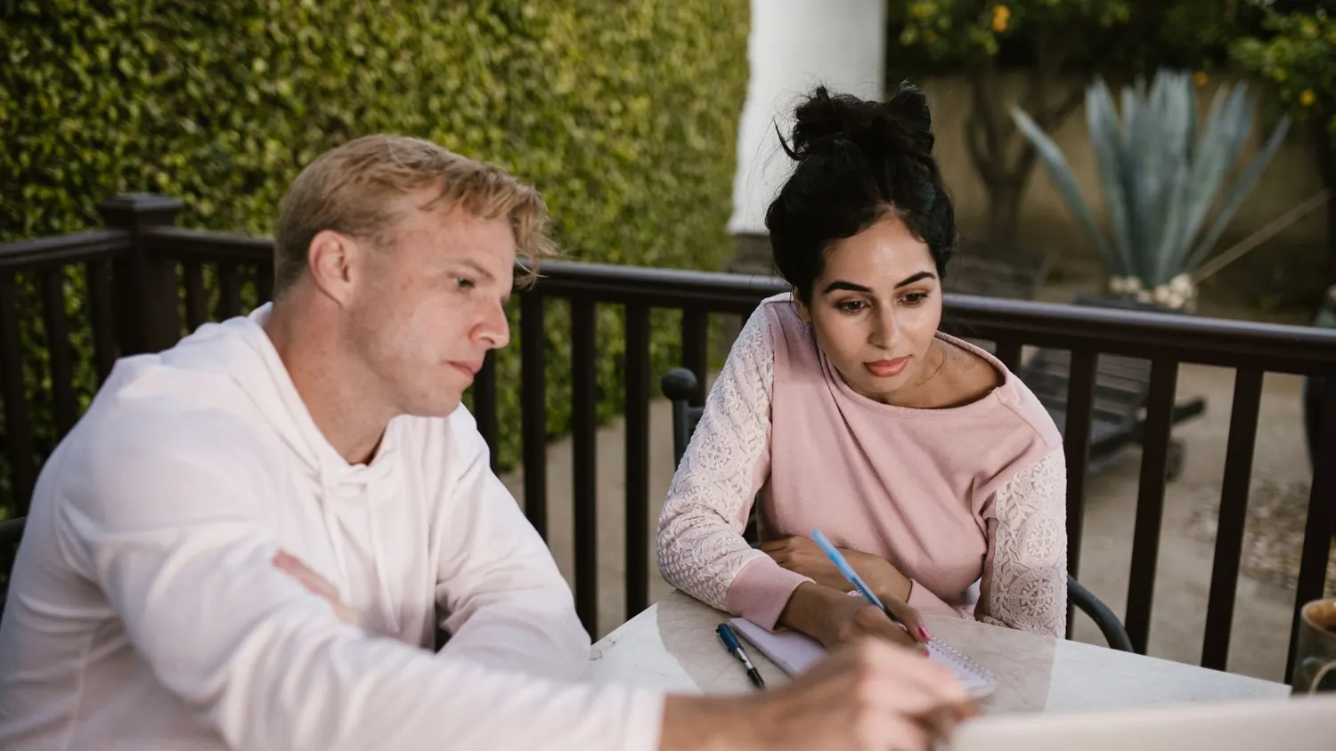 Couple comparing a wedding budget estimate with a printed quote on a laptop