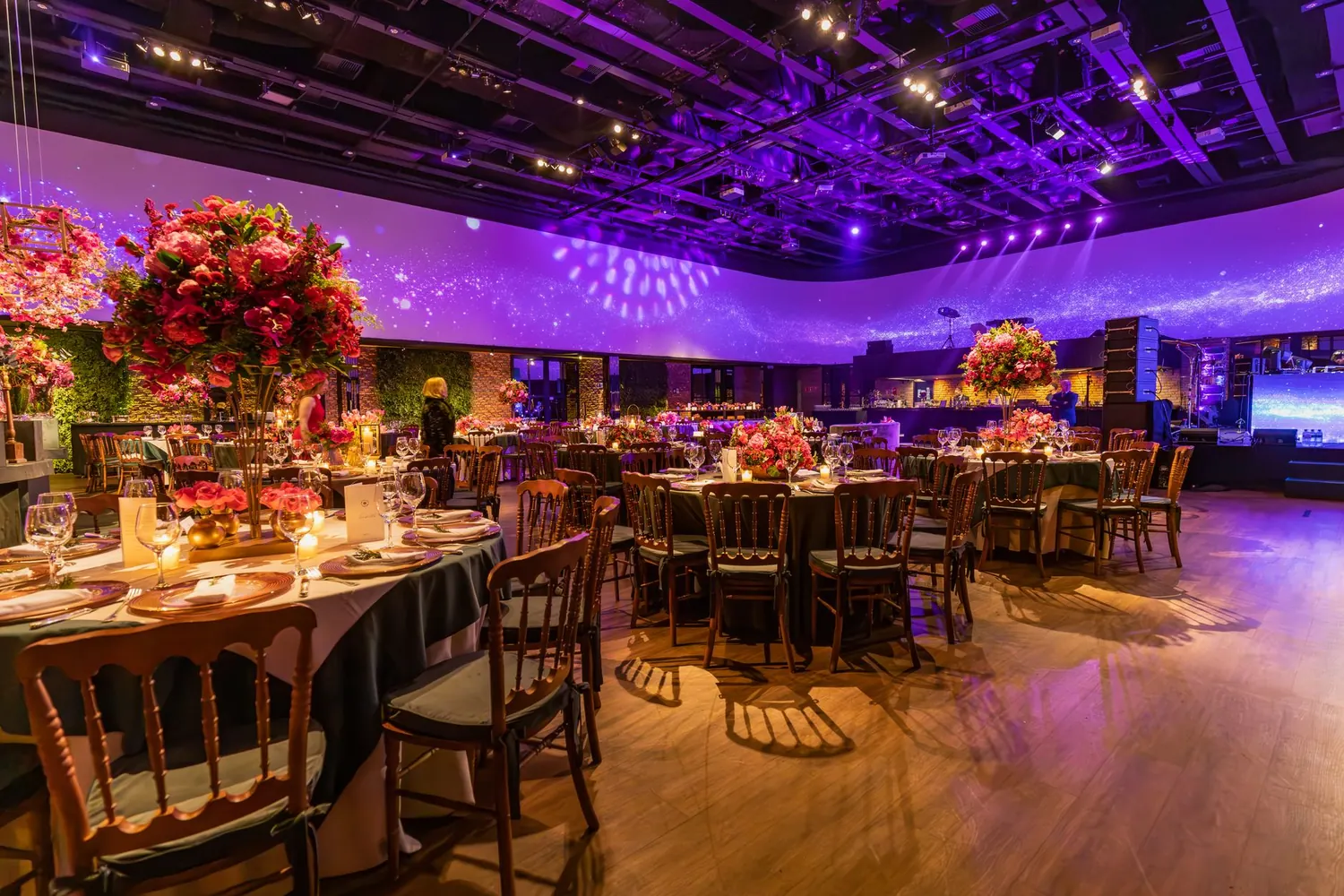 Event palace ballroom with monumental chandeliers and gold banquet tables for guests