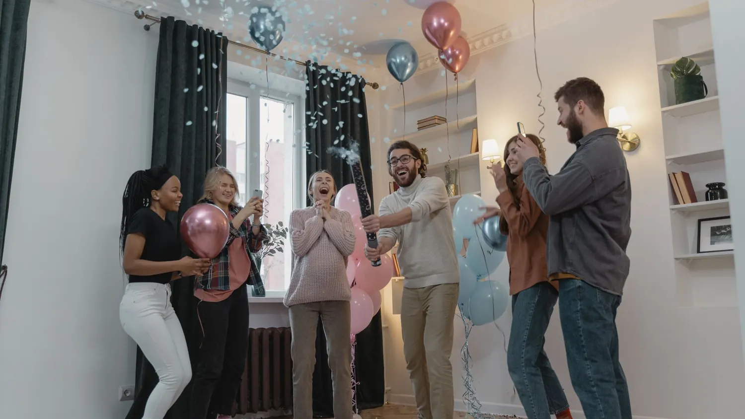 Giant balloon bursting with pink confetti during a gender reveal celebration