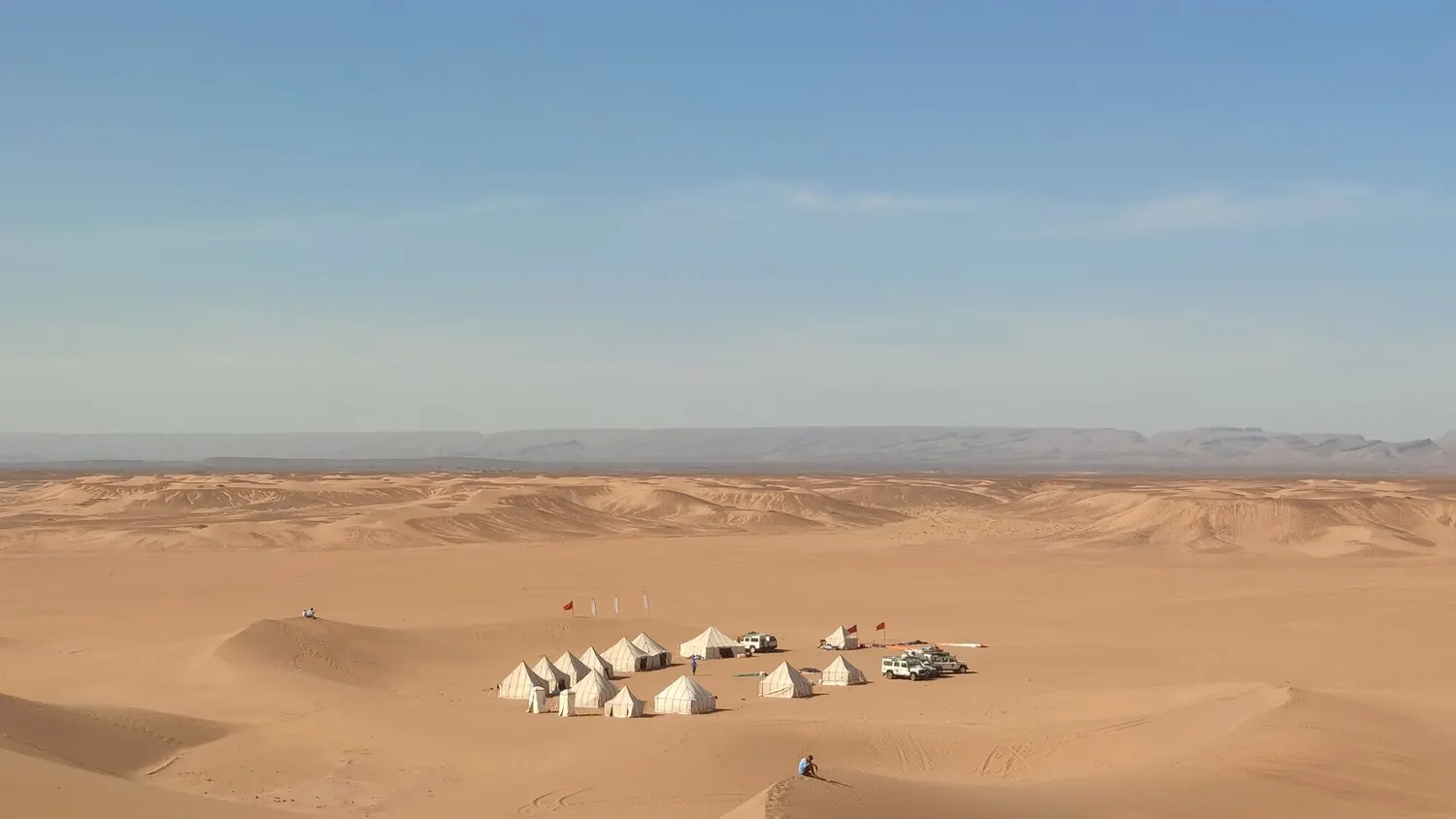 Illuminated Berber tent and rugs at a private Agafay desert camp at sunset