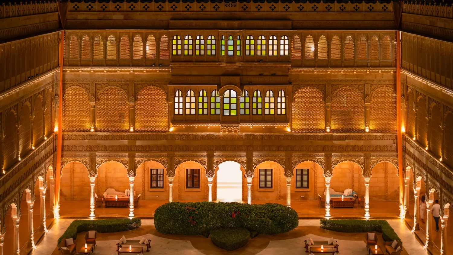 Long candlelit tables and brass lanterns set in a riad courtyard for a wedding dinner