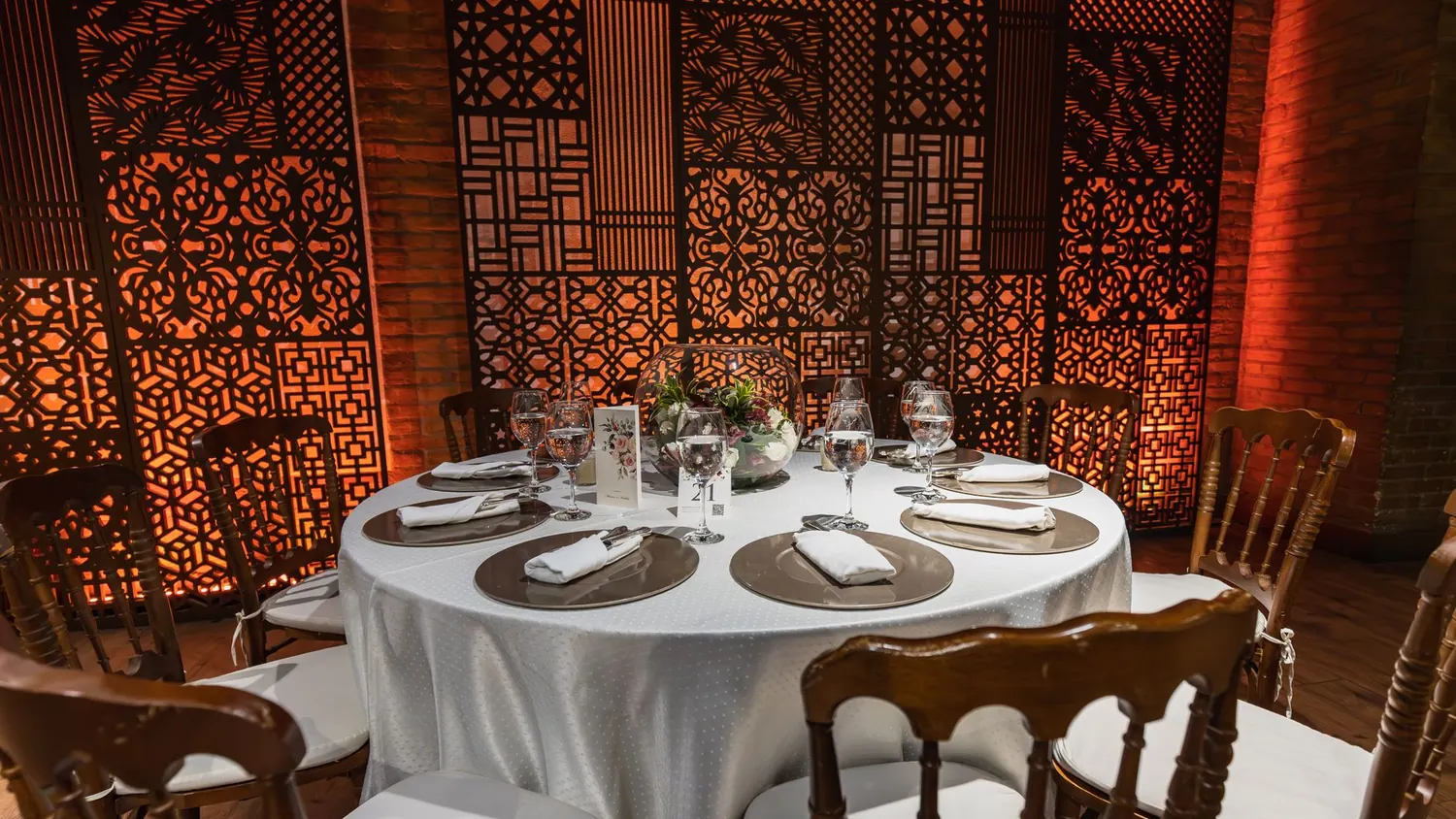 Lanternes marocaines en laiton éclairant une table d'honneur dressée dans un patio de riad
