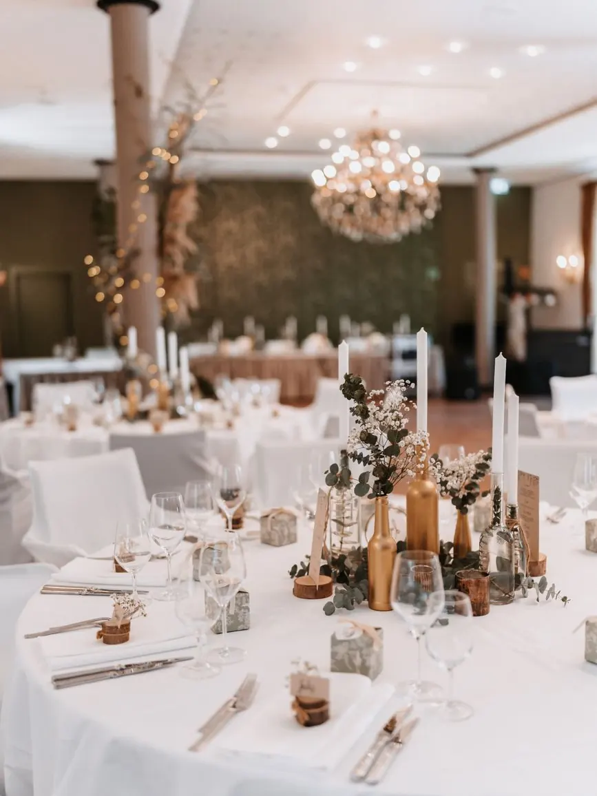 Gold-rimmed plates, candles and white roses on an elegant Marrakech wedding table